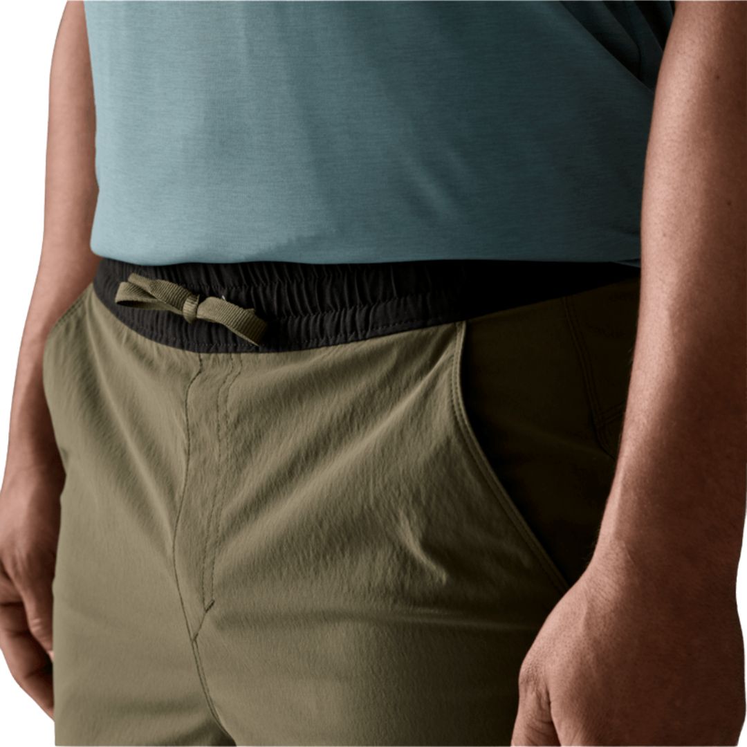 Detalle cinturilla elástica negra de Patagonia Baggies™ Lights Basin Green: cordón de ajuste interior verde oliva sobre tejido nailon reciclado NetPlus® con bolsillo lateral visible.