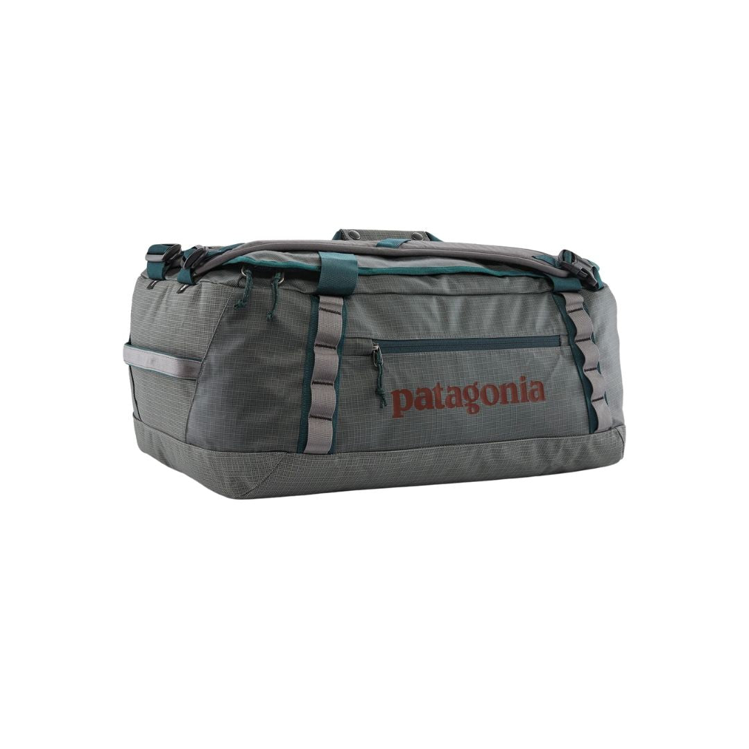 Patagonia Black Hole Duffel 40L color Noble Grey plana: bolsa de viaje gris con asas y detalles verde azulado, bolsillo exterior cremallera y logo Patagonia rojo.