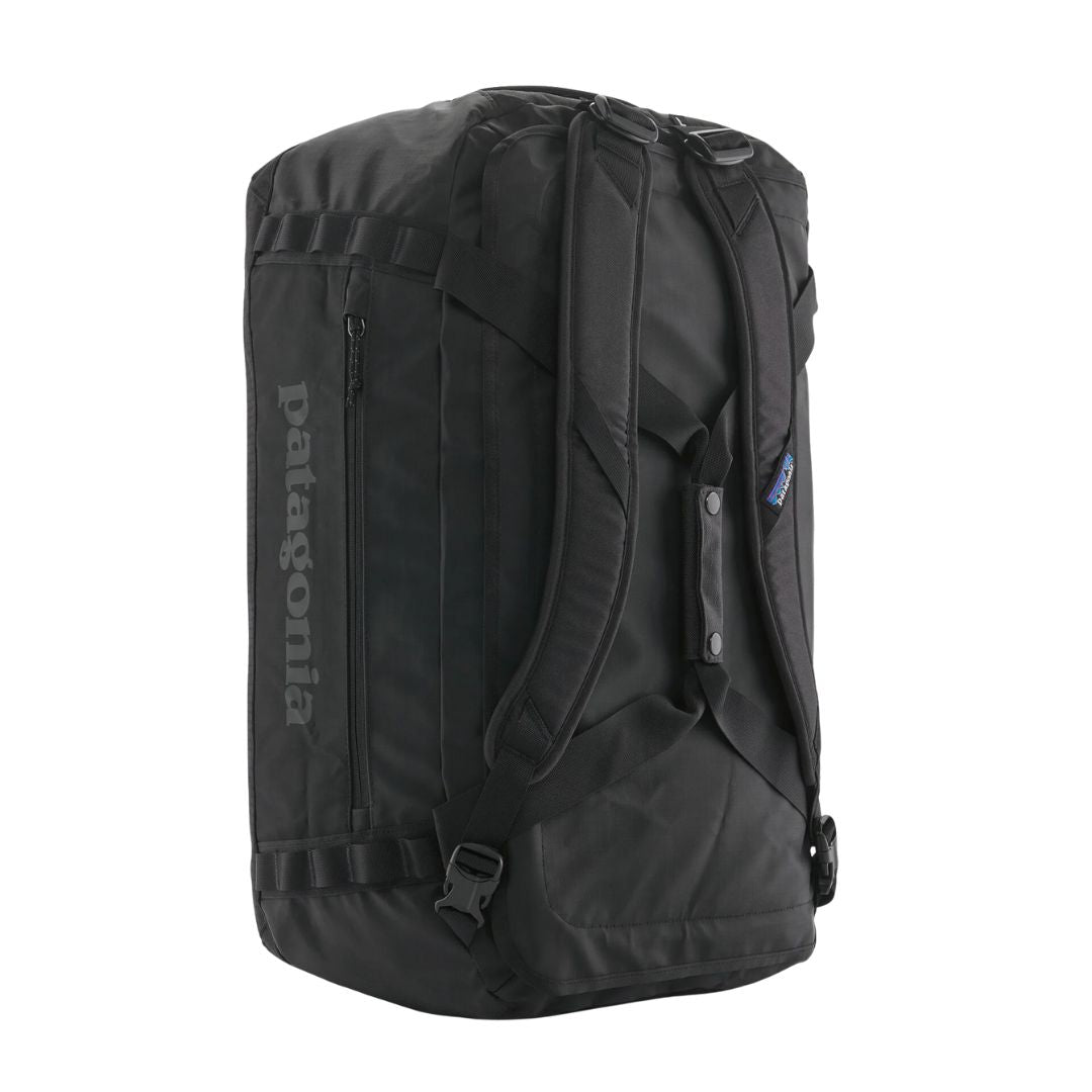 Bolsa de viaje Patagonia Black Hole Duffel 55L negra en vista lateral, con correas acolchadas tipo mochila y logo Patagonia visible.
