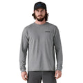 Hombre vistiendo camiseta Patagonia L/S P‑6 Logo Responsibili‑Tee color gris Gravel Heather, vista frontal con logo pequeño en el pecho.