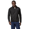 Primer plano de la chaqueta polar Patagonia Better Sweater en negro (Black), con el modelo de frente mostrando el bolsillo de pecho con cremallera y la etiqueta Patagonia.