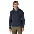 Primer plano de la chaqueta polar Patagonia Better Sweater en azul marino (New Navy), con el modelo de frente enseñando el tejido de punto tipo jersey y el logo bordado.