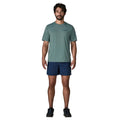 Patagonia Men's Capilene Cool Daily Shirt Boardshort Logo en color blue sage, vista frontal completa con modelo combinada con bañador azul marino y zapatillas de trail, mostrando el corte regular fit y la ligereza del tejido técnico Capilene.
