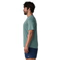 Patagonia Men's Capilene Cool Daily Shirt Boardshort Logo en color blue sage, vista lateral con modelo, mostrando el corte regular fit, las mangas montadas y el tejido jaspeado de poliéster reciclado en verde azulado.