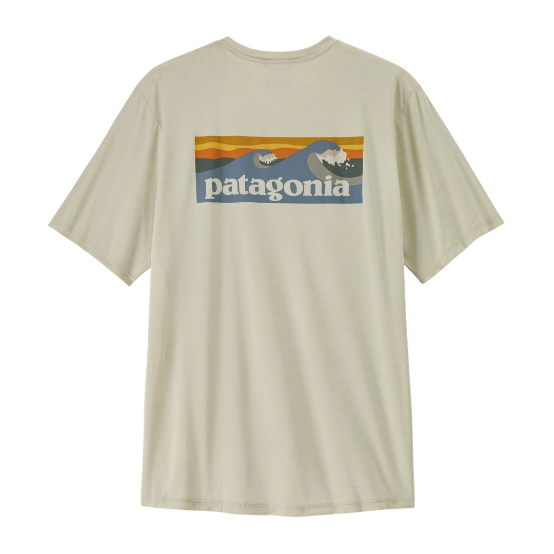Patagonia Men's Capilene Cool Daily Shirt Boardshort Logo en color blanco dyno  vista trasera de producto plano sin modelo, mostrando el estampado completo Boardshort Logo con olas de surf en tonos verde petróleo y crema enmarcadas en rectángulo sobre fondo verde azulado jaspeado.