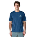 Patagonia Men's Capilene Cool Daily Shirt Great Waves en color clement blue light clement blue x-dye, vista frontal con modelo, camiseta técnica de manga corta con logo Great Waves Great Pacific Iron Works en el pecho izquierdo sobre tejido de poliéster reciclado.