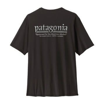 Camiseta Patagonia Capilene Cool Daily Hut Tripper en color negro, vista trasera con el logotipo Patagonia y el gráfico Hut Tripper inspirado en los antiguos catálogos de Chouinard Equipment.