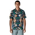  Patagonia Men's Go-To Shirt en estampado kaleido black, vista frontal con modelo combinada con pantalón corto azul grisáceo, mostrando el estampado caleidoscópico de flores abstractas en tonos naranja, verde, azul y crema sobre fondo negro, el cuello con solapas, la tapeta de botones y el corte slim fit en tejido de algodón orgánico y poliéster reciclado.