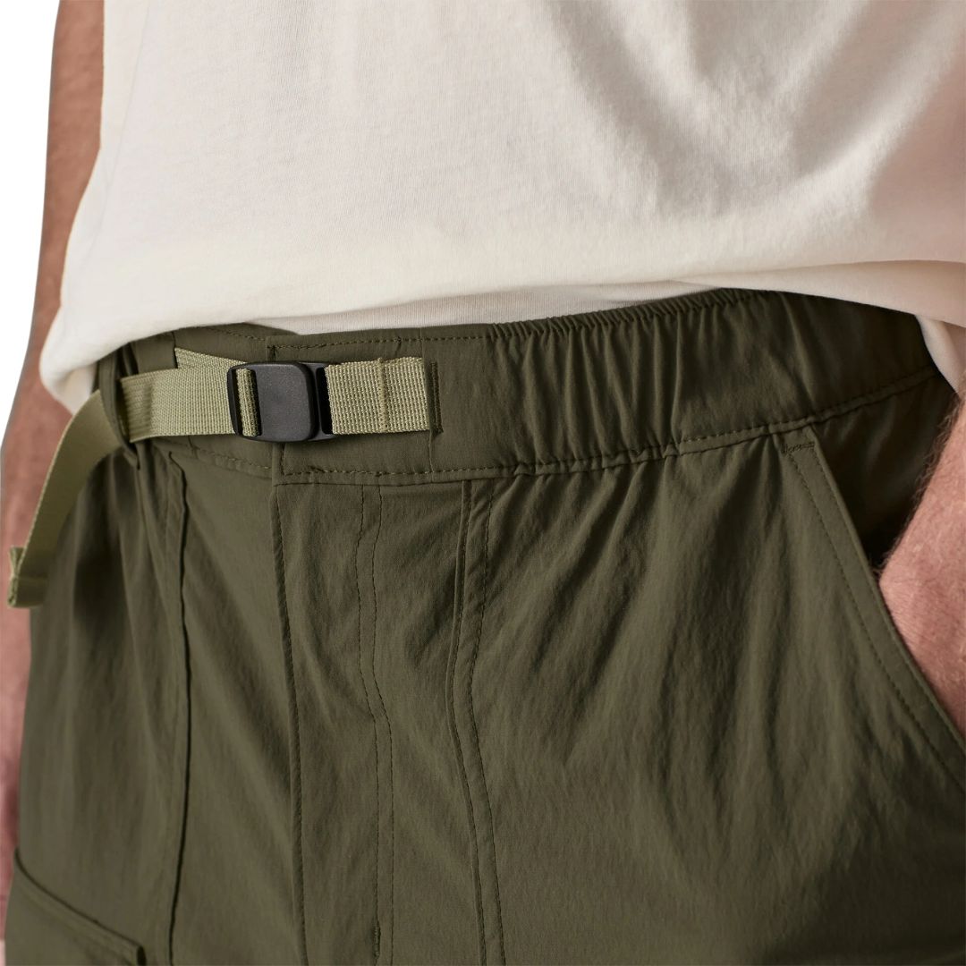 Detalle de cinturón integrado de Patagonia Outdoor Everyday Shorts 6" Basin Green: hebilla ajustable negra con correa de nylon beige sobre cinturilla elástica verde oliva.