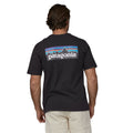 Otro hombre usando la camiseta negra Patagonia Men's P-6 Logo Responsibili-Tee, vista trasera con logotipo en la espalda.