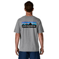Camiseta Patagonia P-6 Logo Responsibili-Tee en color gris jaspeado (Gravel Heather), modelo visto de espaldas mostrando el icónico logotipo P-6 con las montañas y el degradado de colores.