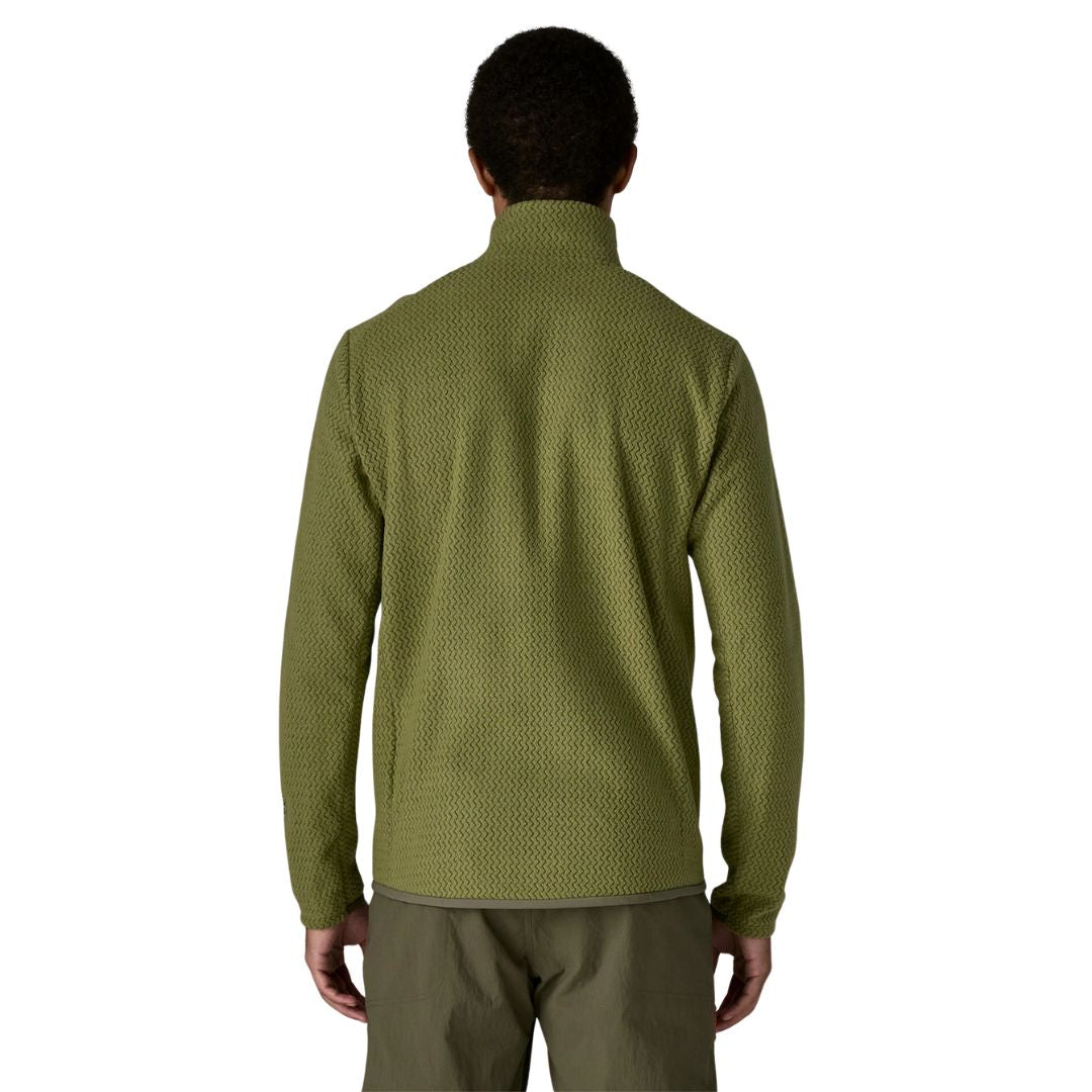 Patagonia Men's R1 Air Fleece Jacket en color caper green, vista trasera con modelo, mostrando el tejido jacquard en zigzag de poliéster reciclado, costuras off-shoulder descentradas y ribete tejido en el bajo.