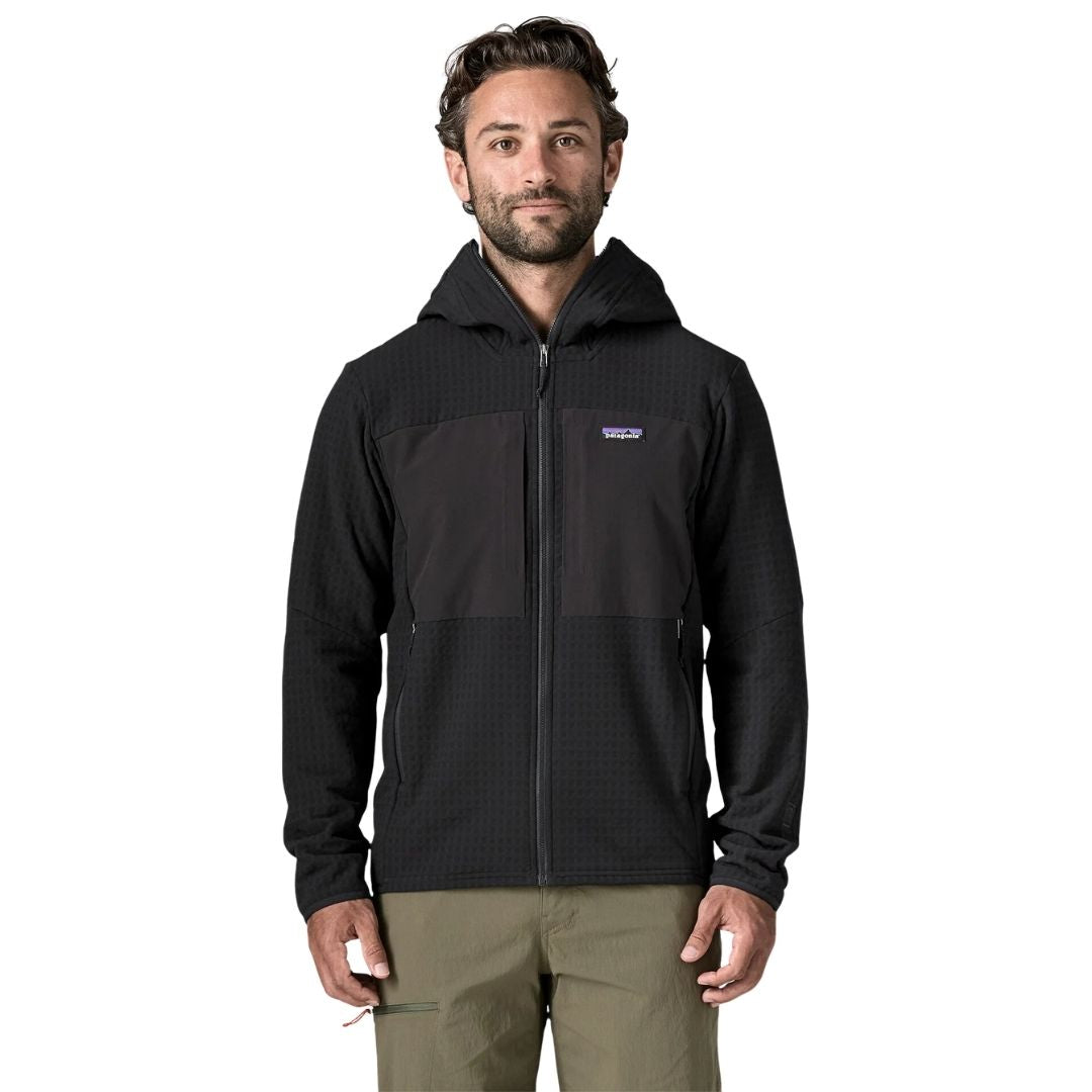 Chaqueta Patagonia R2 TechFace Hoody en Black, modelo de frente mostrando la capucha, el cierre de cremallera completa y los bolsillos calientamanos laterales.