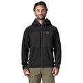 Chaqueta Patagonia R2 TechFace Hoody en Black, modelo de frente mostrando la capucha, el cierre de cremallera completa y los bolsillos calientamanos laterales.