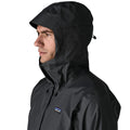 Patagonia Torrentshell 3L color negro, detalle capucha ajustable con visera laminada estructurada, cuello de microforro polar, cordón de ajuste y parche logo P-6.