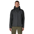 Patagonia Torrentshell 3L color negro, vista frontal en modelo: capucha guardada, cremallera central con solapa antiintemperie, bolsillos calientamanos y parche logo P-6.