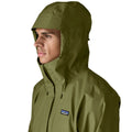 Patagonia Torrentshell 3L color Caper Green, detalle capucha ajustable con visera laminada estructurada, cuello de microforro polar, cordón de ajuste y parche logo P-6.