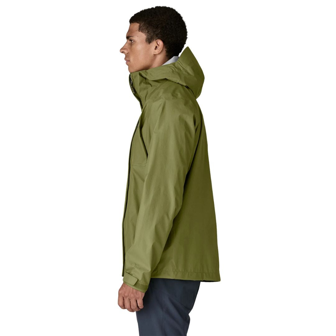 Patagonia Torrentshell 3L color Caper Green, vista lateral en modelo: capucha guardada, cierre de velcro en puño y tejido ripstop ECONYL® impermeable H2No®.