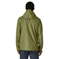Patagonia Torrentshell 3L color Caper Green, vista trasera en modelo: capucha ajustable, triple capa H2No® en nailon ripstop ECONYL® 100% reciclado y bajo ajustable.