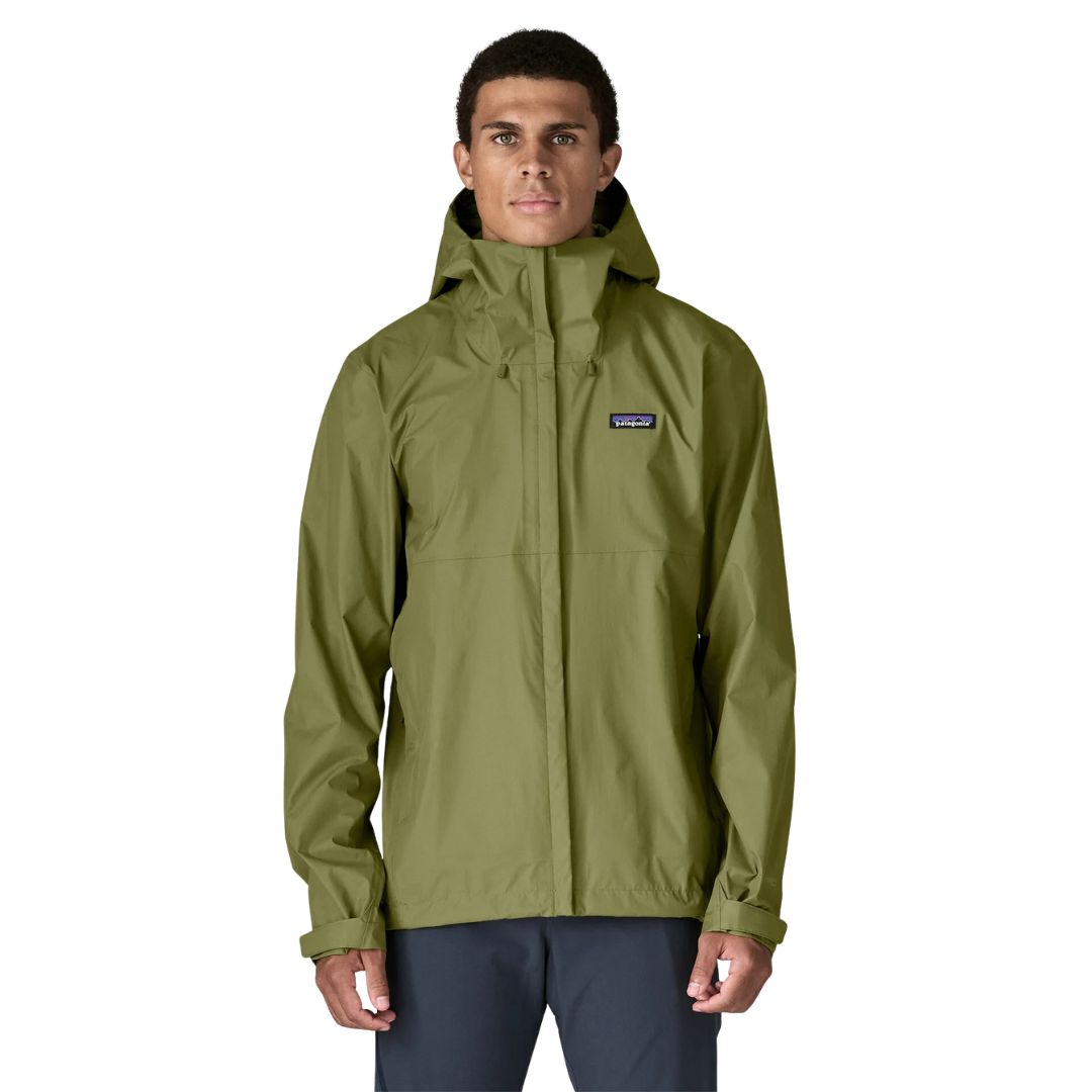 Patagonia Torrentshell 3L color Caper Green, vista frontal en modelo: capucha guardada, cremallera central con solapa antiintemperie, bolsillos calientamanos y parche logo P-6.