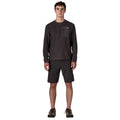Patagonia M's R1 Air Crew en color negro Black — vista frontal completa sobre modelo con pantalón corto y zapatillas de montaña, mostrando el largo y el corte recto del forro polar técnico reciclado.