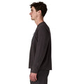 Patagonia M's R1 Air Crew en color negro Black — vista lateral sobre modelo, mostrando el perfil del tejido jacquard en zigzag, el bolsillo con cremallera en el pecho y el logo R bordado en el bajo lateral.