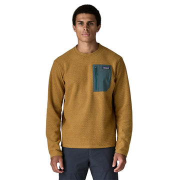 Patagonia M's R1 Air Crew en color marrón Bobcat Brown — vista frontal sobre modelo, con tejido jacquard en zigzag de poliéster reciclado y bolsillo con cremallera en el pecho izquierdo en contraste verde azulado con etiqueta Patagonia.
