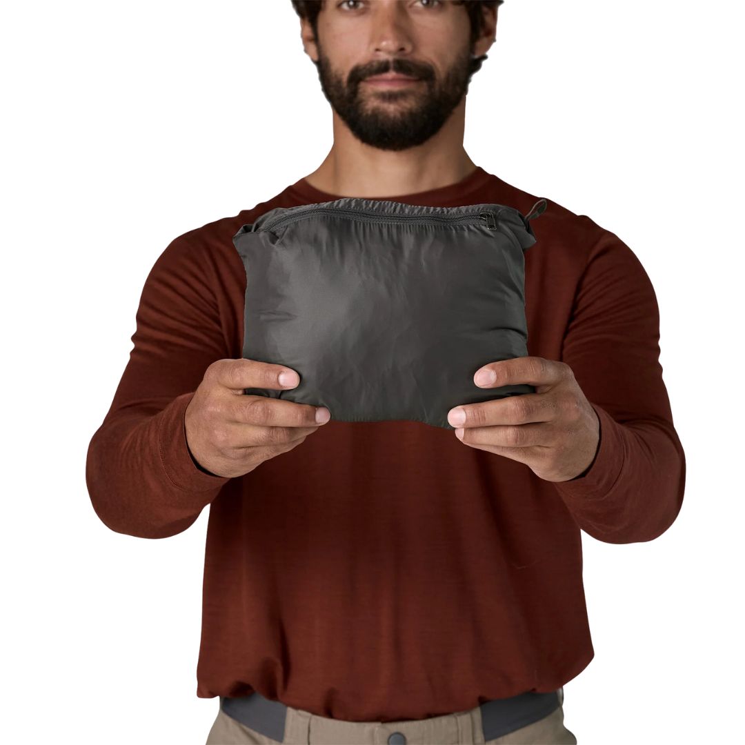 Chaqueta Patagonia Nano Puff® Jacket color negro plegada en su propio bolsillo, vista frontal.