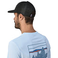 Patagonia P-6 Logo Trucker Hat negra gorra trucker con malla trasera de poliéster reciclado y cierre ajustable snapback vista trasera con modelo.