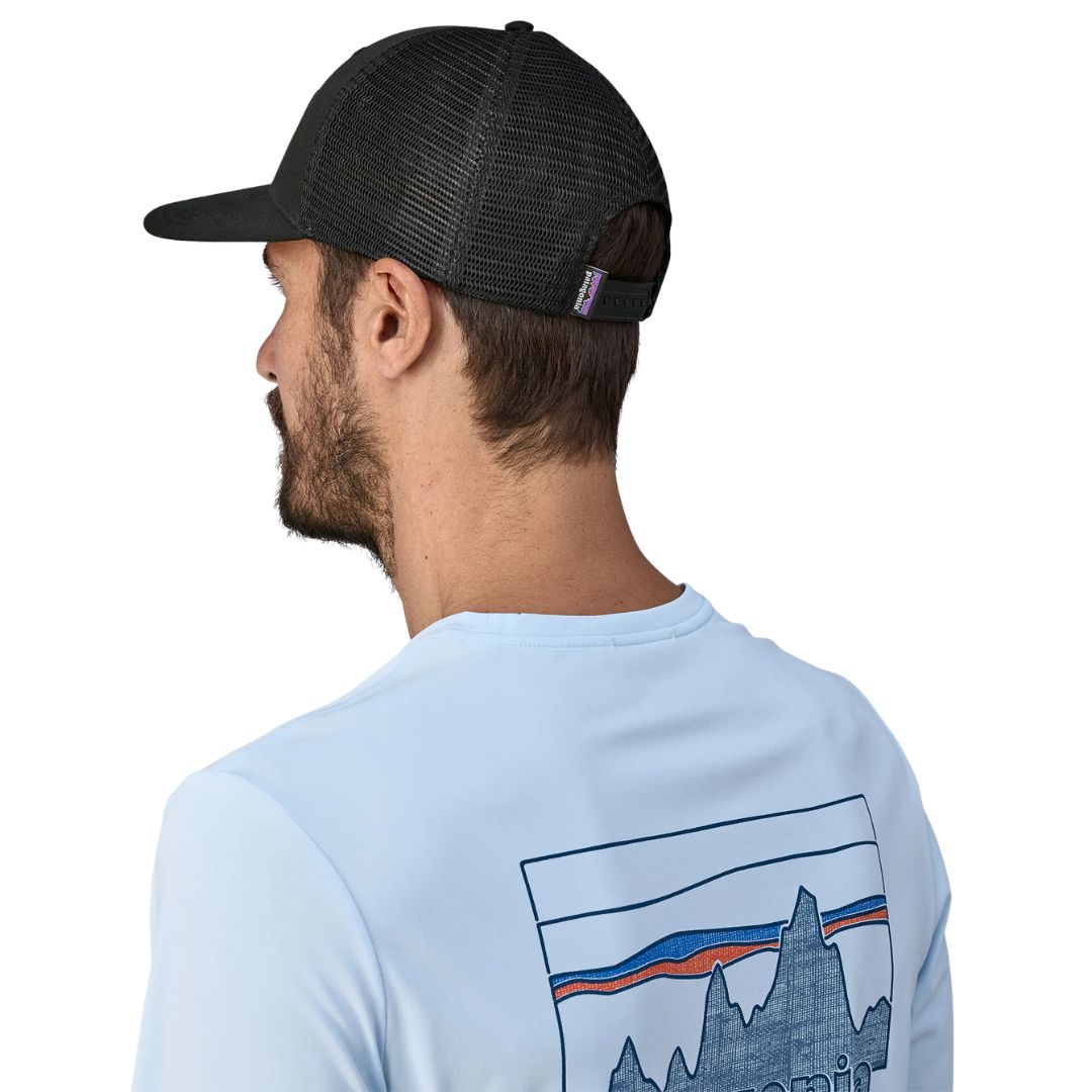 Patagonia P-6 Logo Trucker Hat negra gorra trucker con malla trasera de poliéster reciclado y cierre ajustable snapback vista trasera con modelo.