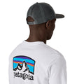 Gorra trucker Patagonia P-6 Logo en color gris (Forge Grey), modelo visto de espaldas con la correa ajustable de broches y la rejilla de malla trasera.