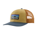 Gorra trucker Patagonia P-6 Logo en color mostaza con visera azul (Lynx Tan), vista de perfil con el parche P-6 bordado y la rejilla de malla naranja.
