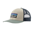 Gorra trucker Patagonia P-6 Logo en color piedra con visera verde salvia (Pumice), vista de perfil con el parche P-6 bordado y la rejilla de malla azul marino.