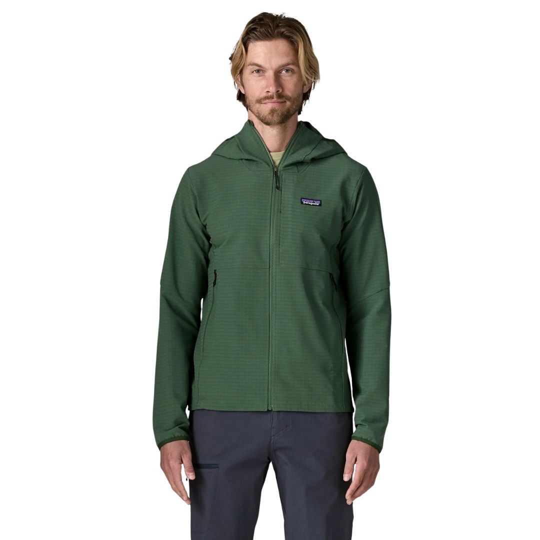 Patagonia R1 TechFace Hoody verde canopy, chaqueta técnica con capucha para hombre. Vista frontal de cuerpo entero con cremallera subida y bolsillo de pecho con logo Patagonia visible.