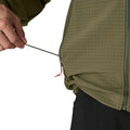 Detalle del bajo ajustable del Patagonia R1® TechFace Hoody: cordón regulable desde el bolsillo calientamanos con tanca, tejido doble en rejilla visible.