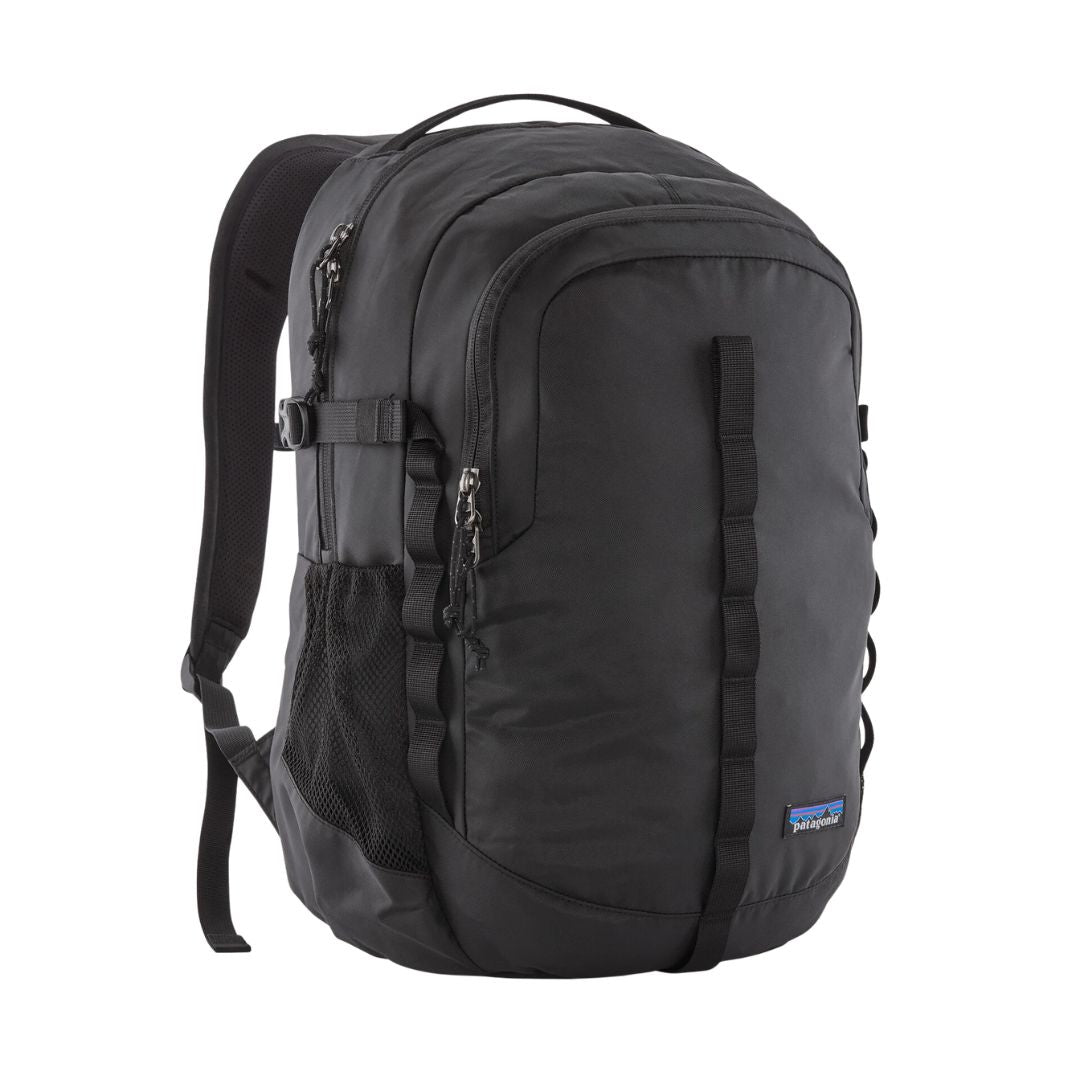 Patagonia Refugio Daypack 26L en color negro, vista de producto en tres cuartos sin modelo, mostrando compartimentos frontales con cremalleras dobles, bolsillo lateral de malla elástica, correas de compresión laterales, asa superior y etiqueta Patagonia.