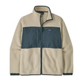 Chaqueta polar Patagonia Retro Pile Fleece Patch Jacket en color beige Pelican sobre fondo blanco: panel de ripstop azul pizarra con dos bolsillos de pecho, parche Patagonia y cuello alto ribeteado.