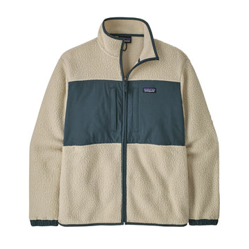 Chaqueta polar Patagonia Retro Pile Fleece Patch Jacket en color beige Pelican sobre fondo blanco: panel de ripstop azul pizarra con dos bolsillos de pecho, parche Patagonia y cuello alto ribeteado.