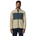 Patagonia Retro Pile Fleece Patch Jacket en color beige Pelican, vista frontal sobre modelo: cremallera completa, cuello alto, panel de ripstop azul pizarra con dos bolsillos y puños elásticos.
