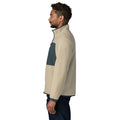Perfil de la chaqueta polar Patagonia Retro Pile Fleece Patch Jacket en color beige Pelican: borreguillo de doble cara, panel de ripstop azul pizarra en el pecho y ribetes elásticos en puño y bajo.