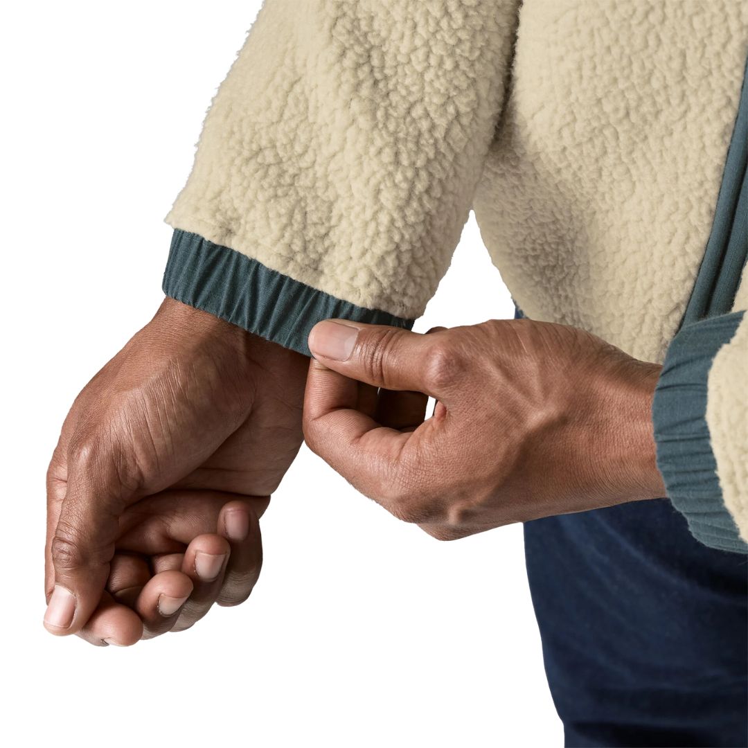 Detalle del puño de la Patagonia Retro Pile Fleece Patch Jacket en color beige Pelican: borreguillo de doble cara y puño elástico de ripstop en azul pizarra ajustado con la mano.