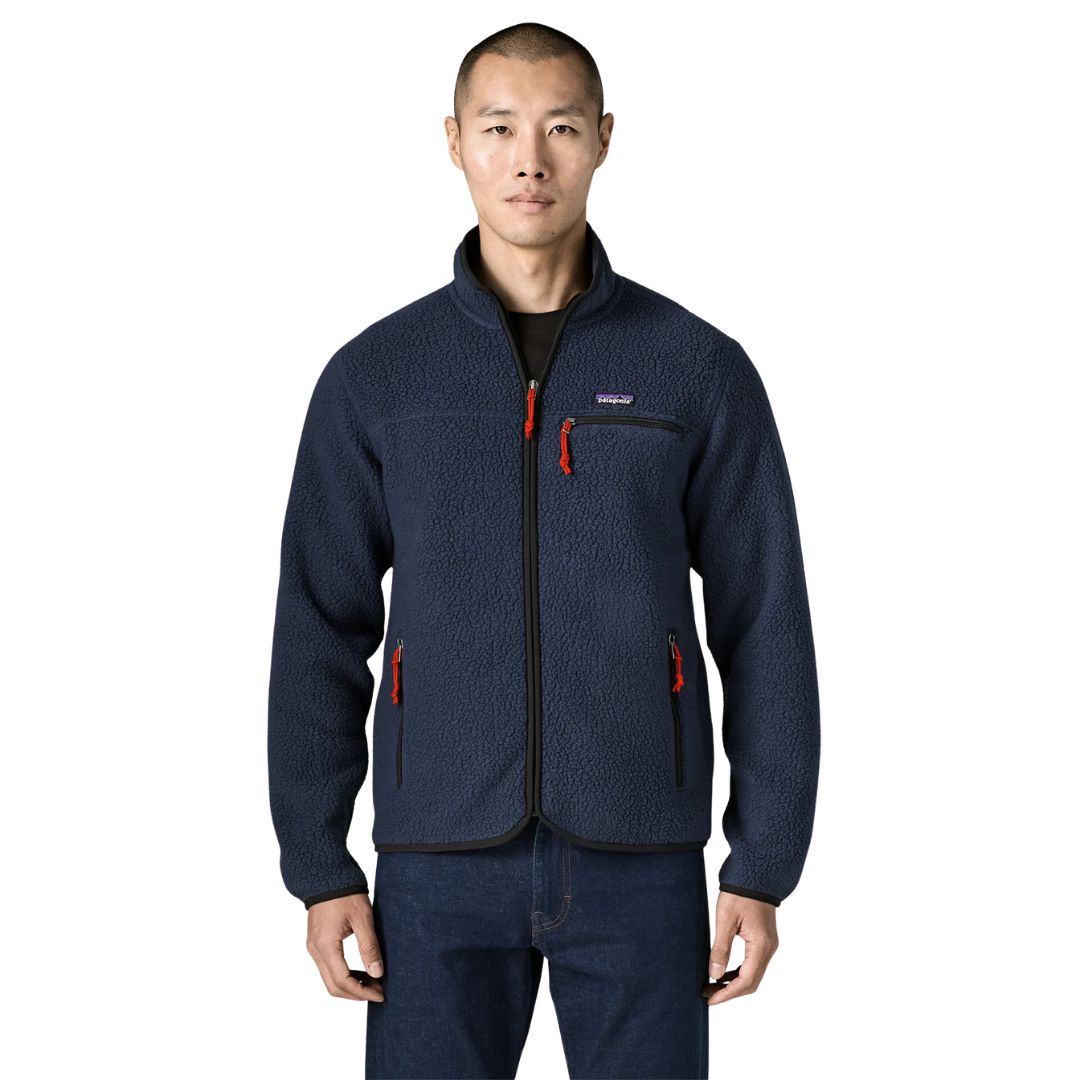Patagonia Retro Pile Fleece Jacket en color azul marino New Navy, vista frontal sobre modelo: cremallera completa con ribete negro, tiradores rojos, bolsillo de pecho y dos calientamanos.