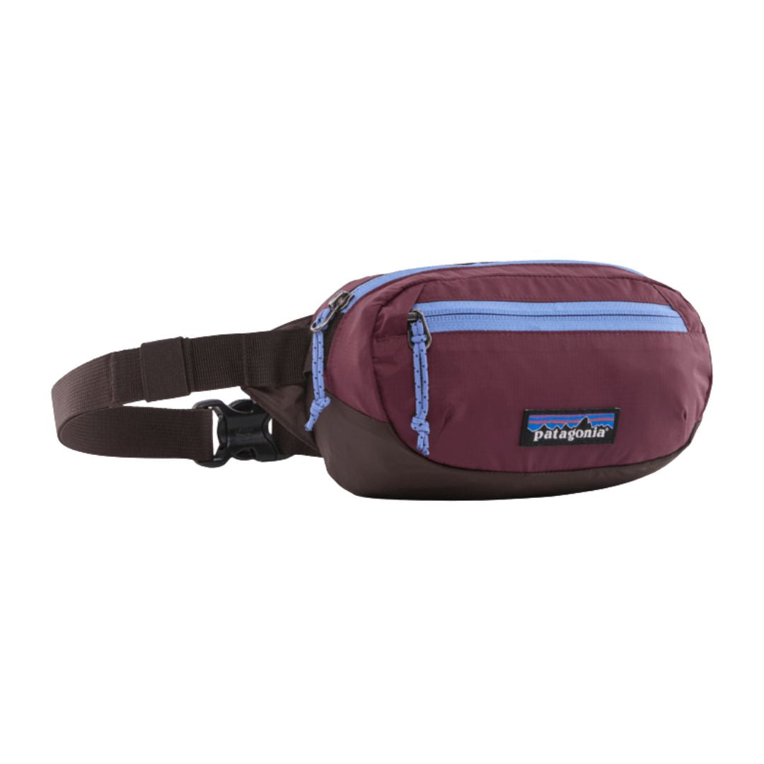 Riñonera Patagonia Terravia Mini Hip Pack en color granate con cremallera azul (Berry/Fig), vista de perfil con el bolsillo frontal y el parche Patagonia.