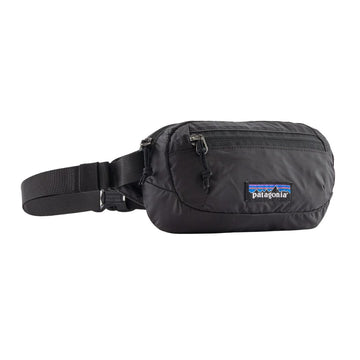 Patagonia Terravia Mini Hip Pack 1L en color negro, vista de producto en tres cuartos sin modelo, mostrando el compartimento principal con cremallera metálica, el bolsillo frontal de seguridad, la etiqueta Patagonia con logo Fitz Roy y la correa de nailon reciclado con ajustador.