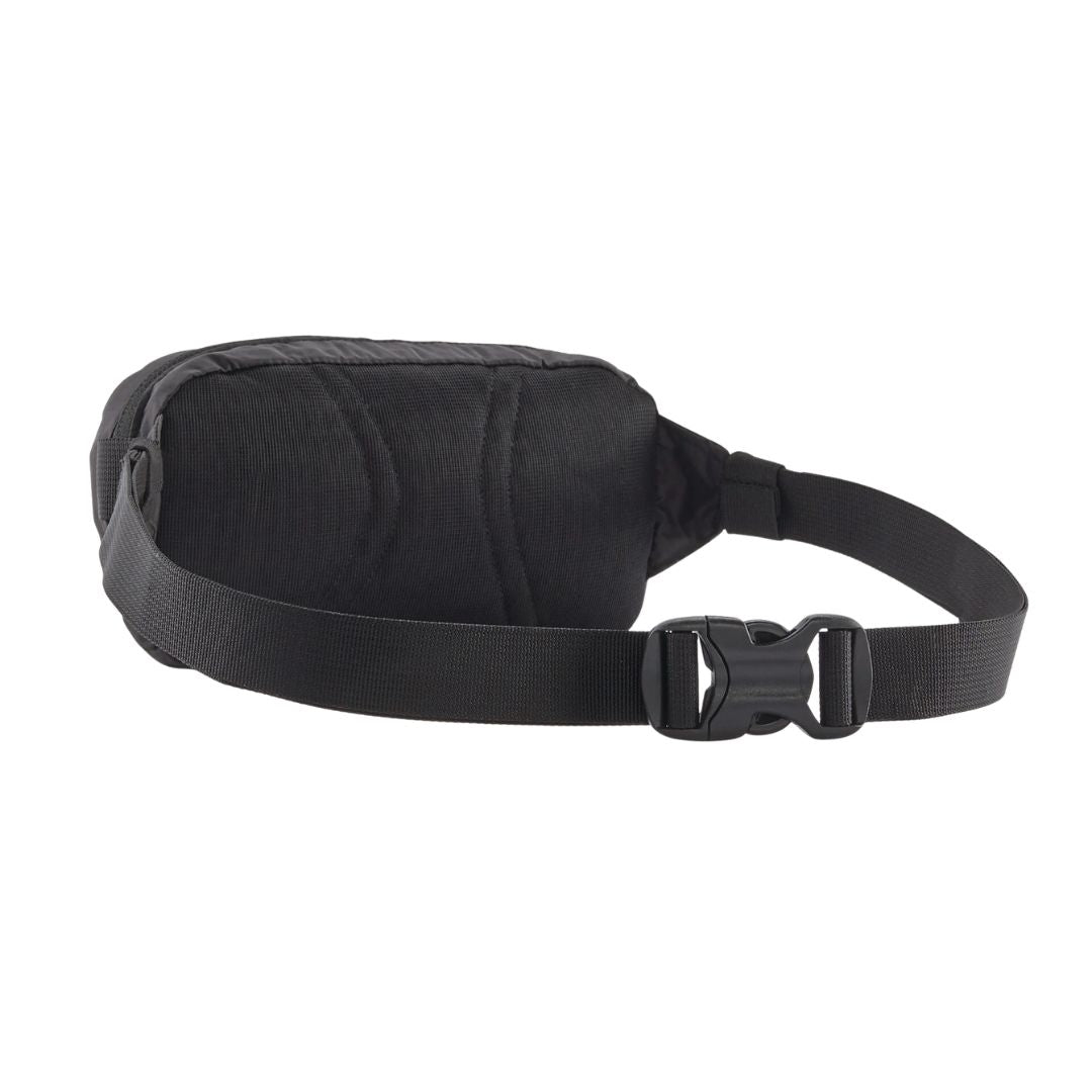 Patagonia Terravia Mini Hip Pack 1L en color negro, vista trasera de producto sin modelo, mostrando el panel trasero de airmesh transpirable de poliéster reciclado, el cinturón antideslizante de nailon reciclado y la hebilla de cierre ajustable.