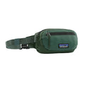 Riñonera Patagonia Terravia Mini Hip Pack en color verde bosque (Canopy Green), vista de perfil con la cremallera cerrada, el bolsillo frontal y el parche Patagonia.