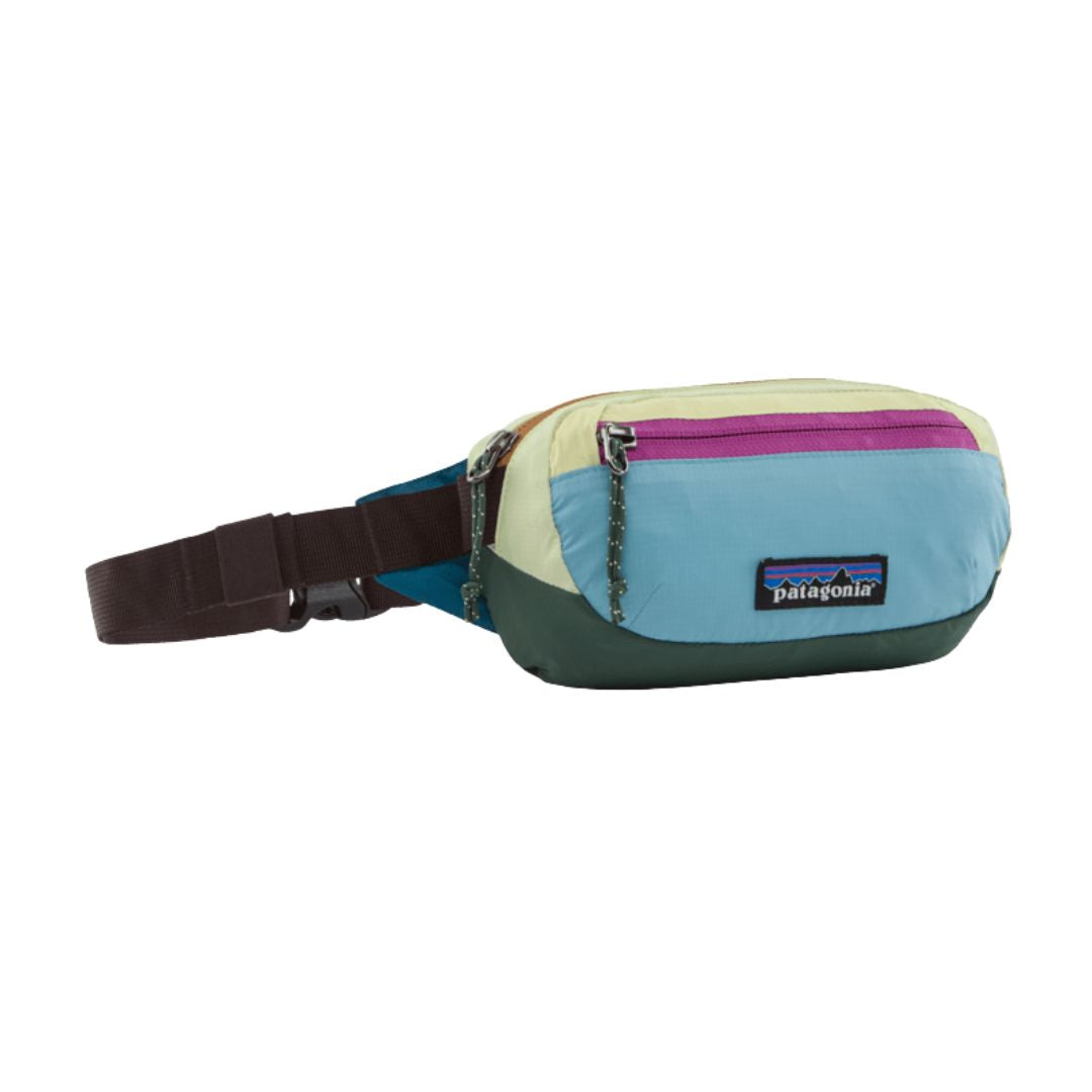 Riñonera Patagonia Terravia Mini Hip Pack en colorway Patchwork Snowmelt Blue, vista de perfil con la cremallera cerrada, la cinta ajustable y el parche Patagonia.
