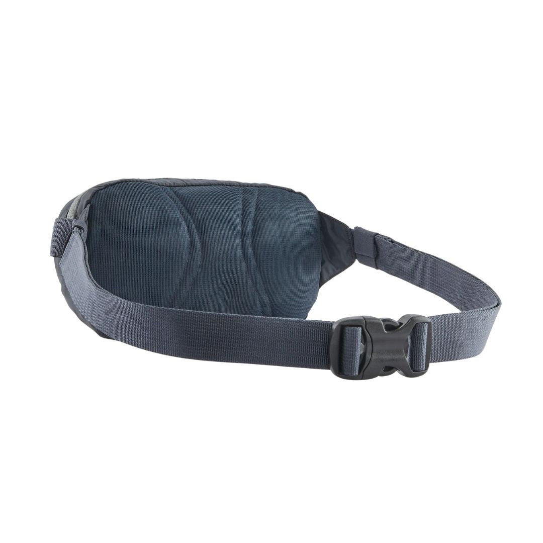 Patagonia Terravia Mini Hip Pack 1L en color smolder blue, vista trasera de producto sin modelo, mostrando el panel trasero de airmesh transpirable en azul marino oscuro, el cinturón antideslizante azul marino y la hebilla de cierre ajustable negra.