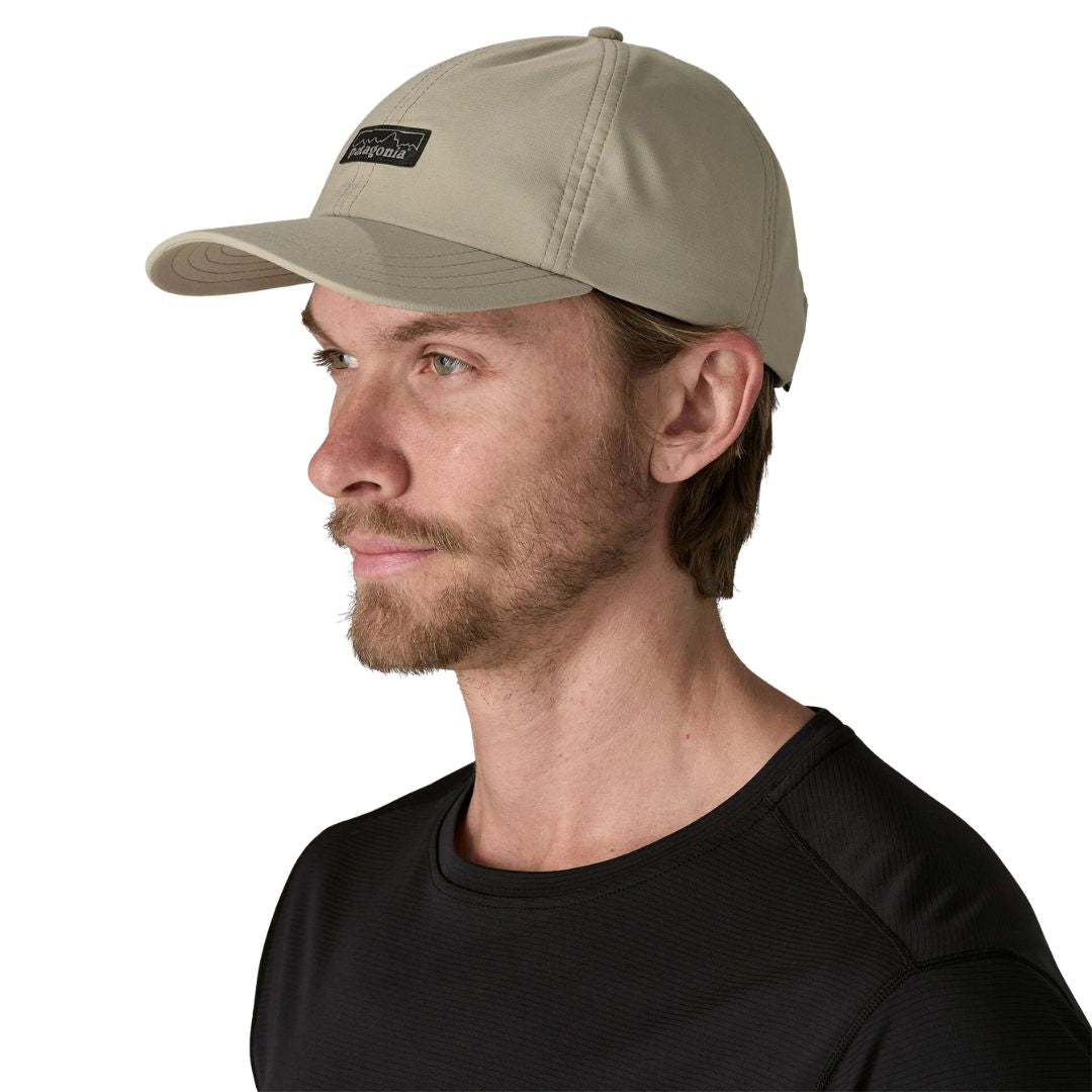 Hombre con la gorra Patagonia Terrebonne Hat verde roca de río para hombre, diseño técnico ligero con visera curva y logo frontal, ideal para running y outdoor.