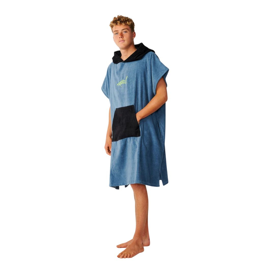 Poncho toalla con capucha Rip Curl en color Bluefin, vista de perfil mostrando el bolsillo canguro negro y el largo hasta el muslo.